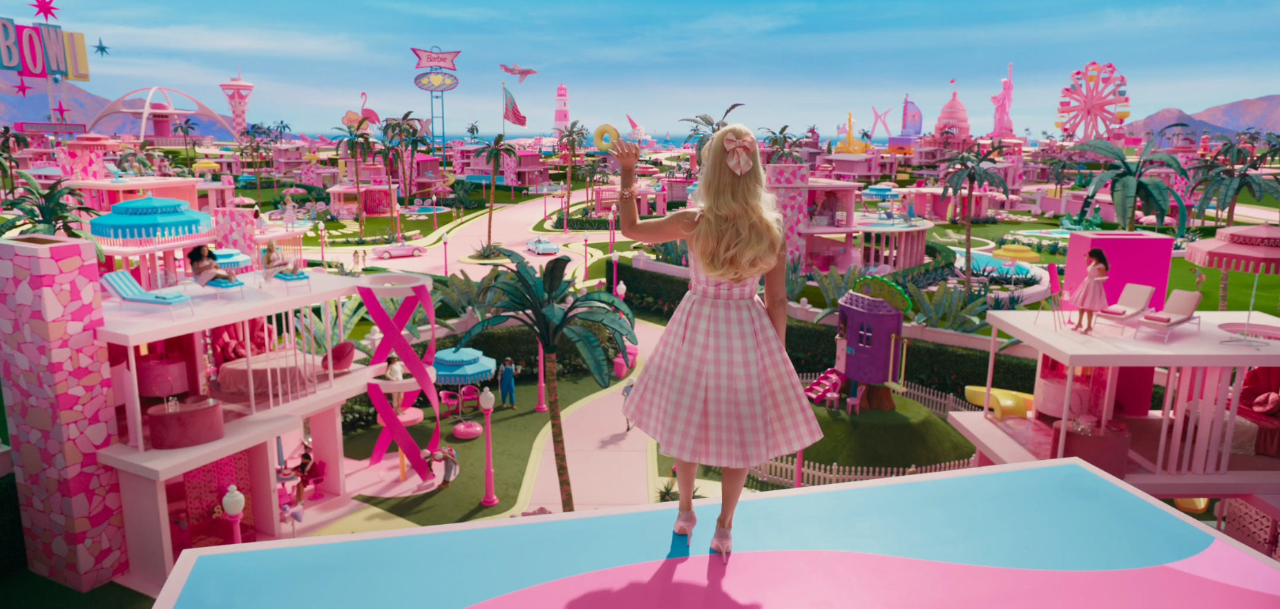 Margot Robbie dans le film Barbie, saluant un monde rose bonbon © Warner Bros